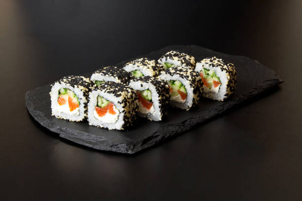 istock Sushi rolls with sesame seeds on a stone Board for sushi 1289717920