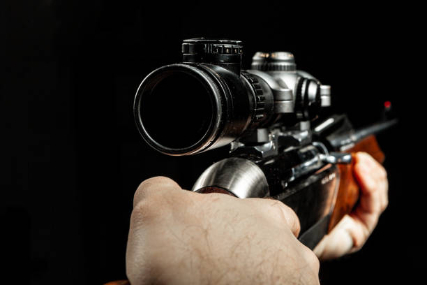 istock Male hands holding hunting rifle on black background 1289723468