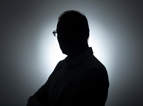 Silhouette of businessman. Male shadow on backlit. Profile of black man in eyeglasses.