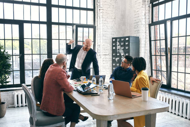 istock Beautiful business people are using gadgets, talking and smiling during the conference in office 1289726036