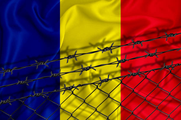 istock Chad flag development, fence mesh and barbed wire. Emigrants isolation concept. With place for your text. 1289726464