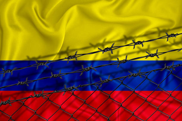 istock colombia flag development, fence mesh and barbed wire. Emigrants isolation concept. With place for your text. 1289727209