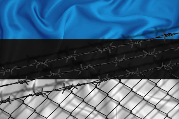 istock estonia flag development, fence mesh and barbed wire. Emigrants isolation concept. With place for your text. 1289727282