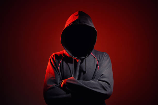 silhouette af homme sans visage dans le capot sur le fond rouge. concept de crime anonyme - capuche photos et images de collection