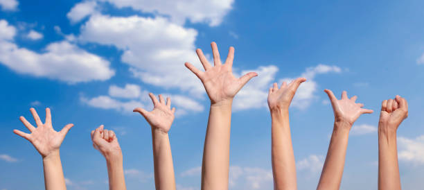 istock happy people hands up in brightens sky. 1289732825