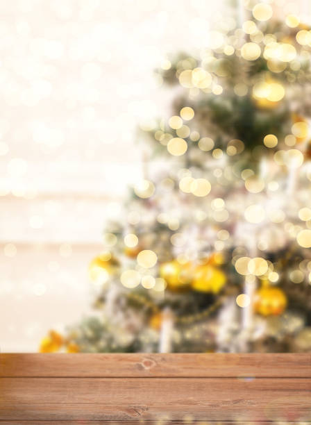 Empty wooden table top and blurred bokeh Christmas tree on the background. stock photo