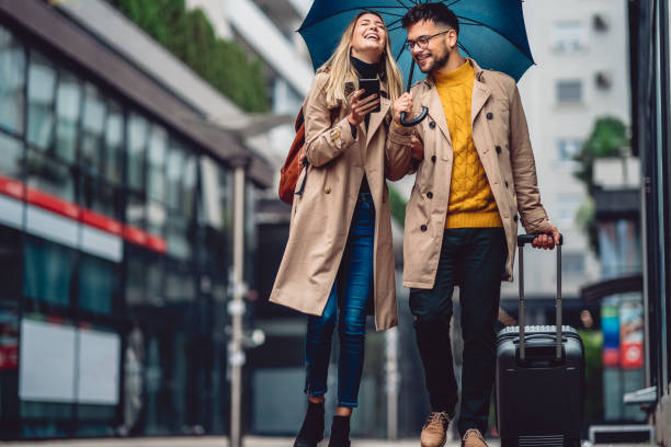 istock beautiful smiling young couple walking in the rain 1289732984