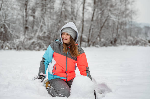 istock Young girl playing or making a snowman in a winter time 1289733239