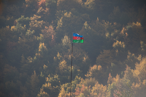 Azerbaijan flag,Waving flag on the mountain. National flag of Azerbaijan on strong wind in the sunny day. Outdoor nature shot