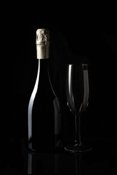 istock Sparkling wine with an empty glass on a dark background. 1289744234