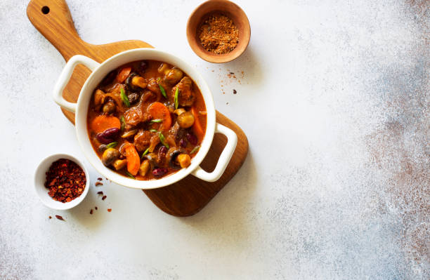 istock Beef, mushrooms and vegetable stew in a pot on gray stone background. Flat lay. Copy space 1289745531