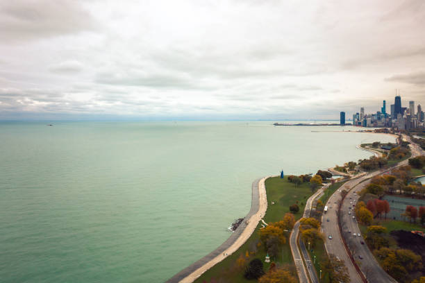 Beautiful aerial skyline view background of the city of Chicago and Lake Shore drive to the right and copy space over Lake Michigan and overcast cloudy sky on the left. Beautiful aerial skyline view background of the city of Chicago and Lake Shore drive to the right and copy space over Lake Michigan and overcast cloudy sky on the left. lake shore drive chicago stock pictures, royalty-free photos & images