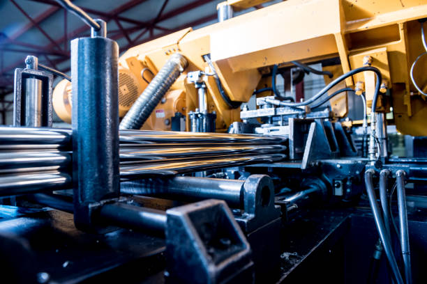 istock Automatic band saw machine with water coolant cutting metal pipes. 1289745911