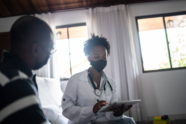 istock Doctor talking to a senior patient at home visit 1289746828