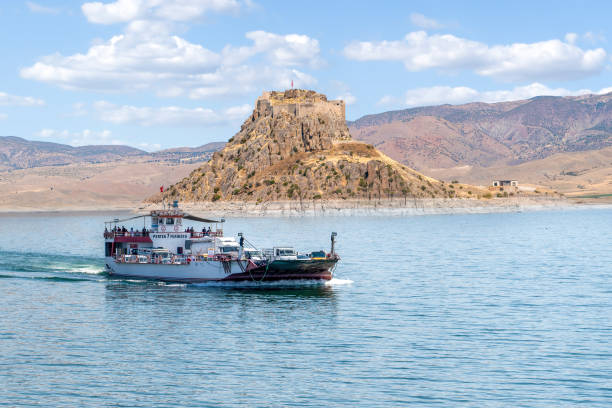 The ferry that connects Elazig and Tunceli cities and the Pertek fortress in the background Pertek, Tunceli, Turkey-September 18 2020: The ferry that connects Elazig and Tunceli cities and the Pertek fortress in the background tunceli stock pictures, royalty-free photos & images