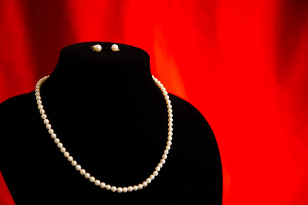 White pearl necklace on reddish brown background. Selective focus and shallow depth of field.