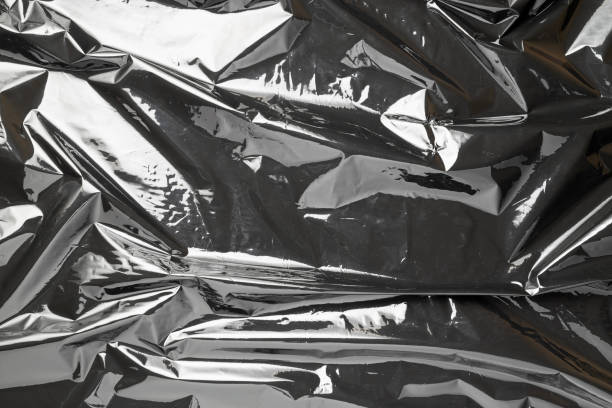 istock Plastic wrap. Black shiny film bag pattern. Transparent dark cellophane texture. Creative crumpled background. 1289751642