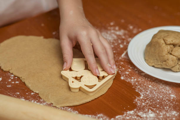 istock Little chef carves house-shaped cookies from ginger dough. 1289751914