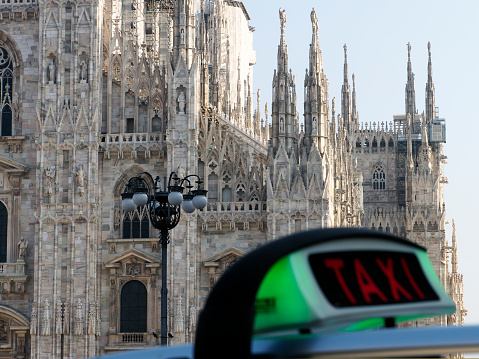 Taxi sign with Duomo on the background, Milano