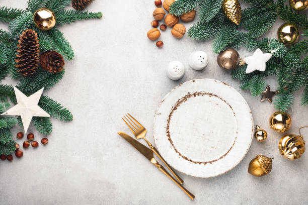 istock Christmas frame background with empty plate, golden cutlery and decorated fir tree 1289755914