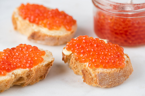 Expensive red caviar and butter on bread toast. Russian appetizer for holidays