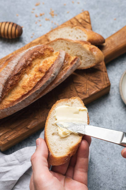istock Spreading butter on baguette bread 1289756017
