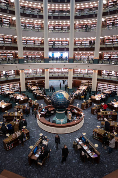 Interior view of an amazing crowded library with a globe on its center stock photo