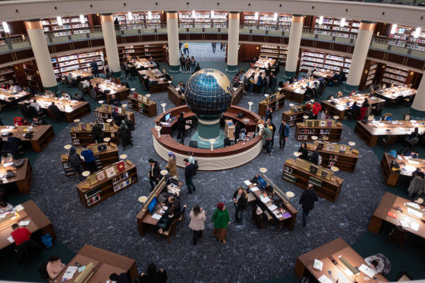 Amazing interior view of a crowded library with a globe on its center stock photo