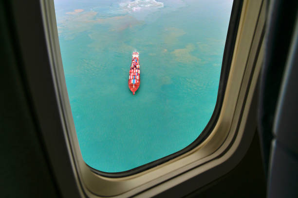 istock Aerial view of cargo ship in transit. View from airplane window. 1289757457