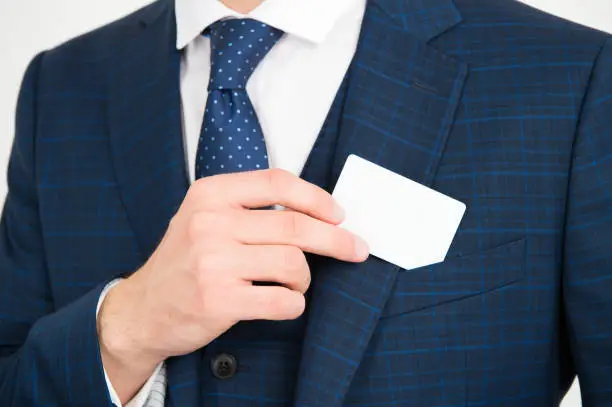 Showing his visiting card. Male hand take card out of suit pocket. Identification paper. Showpiece. Contact details. Formal occasion. Business information, copy space.