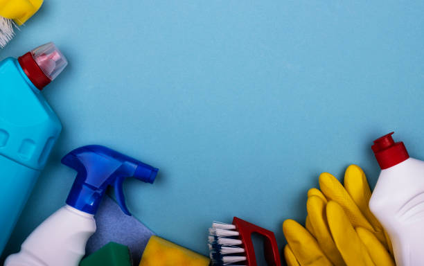 istock cleaning products in plastic bottles, rubber gloves with a sponge on a blue background, top view 1289760111