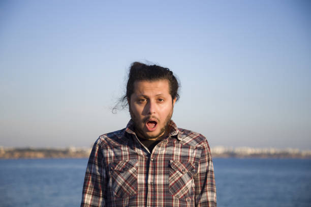 istock Young man looking at camera with shocked facial expression. 1289761234
