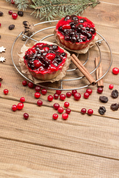 istock Berry muffins on metal tray. Cinnamon sticks, raisins and cranberries on table. 1289762480
