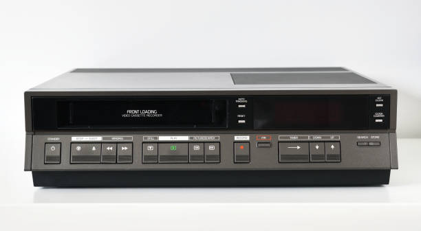 ein alter vintage-videorecorder aus den 1980er jahren steht auf einem dunklen tisch mit einem videoband. retro-videorekorder. - vcr stock-fotos und bilder