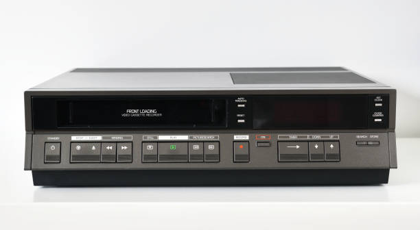 un vecchio videoregistratore vintage degli anni '80 si trova su un tavolo scuro con una videocassetta. videoregistratore retrò. - vcr foto e immagini stock
