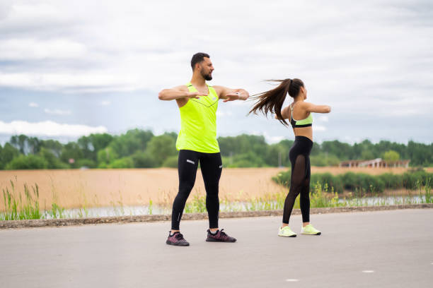 istock Sporty couple exercising before training. Athletic pair preparing for jogging outdoors. Sport active lifestyle 1289763902