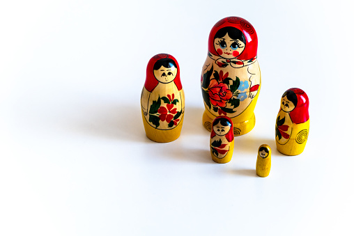 Matryoshka dolls decorated with patterns stand in a row. A cultural symbol. Human appearance.