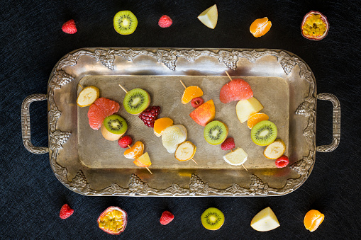 Full of vitamins, juicy fruit skewers served on a stylish tray. Concept of healthy eating and diet