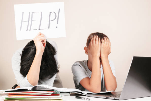 istock Learning difficulties, remote education, online learning and working at home. Tired mother and sad kid need help to do homework 1289767697