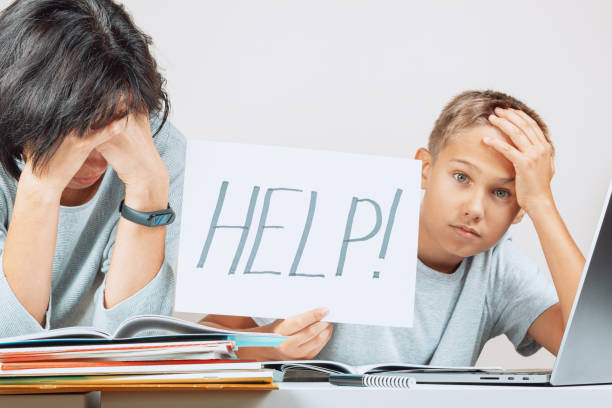 istock Learning difficulties, remote education, online learning concept. Tired mother and sad kid need help to do homework at home 1289767707