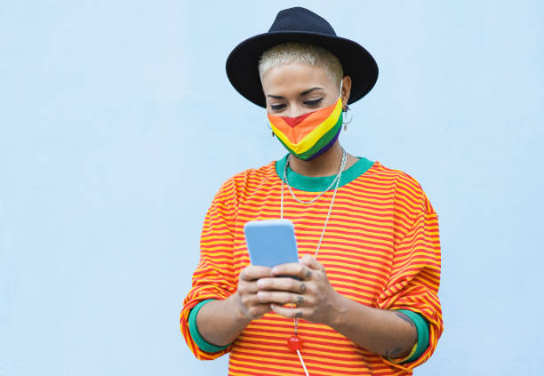 Young hipster girl with smartphone while wearing protective face mask for coronavirus Young hipster girl with smartphone while wearing protective face mask for coronavirus lgbtqia rights photos stock pictures, royalty-free photos & images