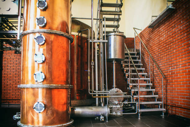 equipos industriales para la producción de brandy. el cobre sigue alambique dentro del destilador para destilar uvas y producir licores. ruidos y grano grande - estilización bajo la película. enfoque suave - destilería fotografías e imágenes de stock