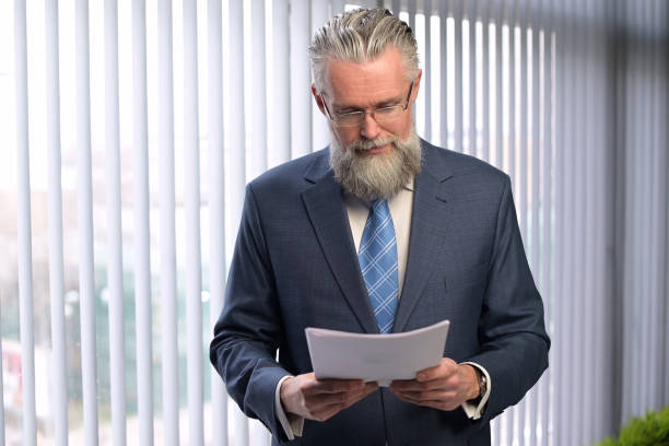 istock The mature gray-haired company executive examines the reports 1289773664