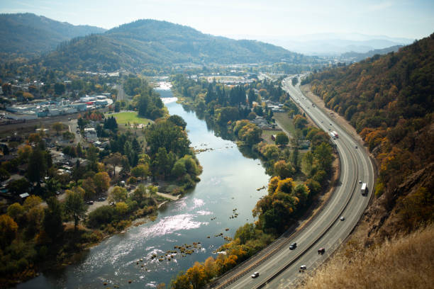 freeway follows the river - curve driving winding road landscape stock-fotos und bilder