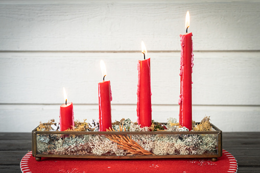 Christmas vintage card. Fourth Advent. Four red burning candles in a beautiful glass candlestick. Christmas holiday in Christian countries. Swedish traditions.