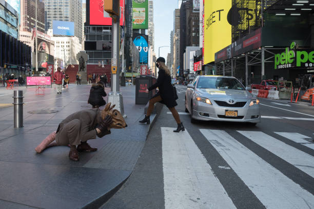 Manhattan, New York. December 03, 2020. Actor Jonothon Lyons dressed in a giant rat costume at a crosswalk in Times Square. Jonothon, who works in physical theater and puppetry, these days, wears the costume of a rat with a huge tail and a face-covering mask to startle people in New York City.