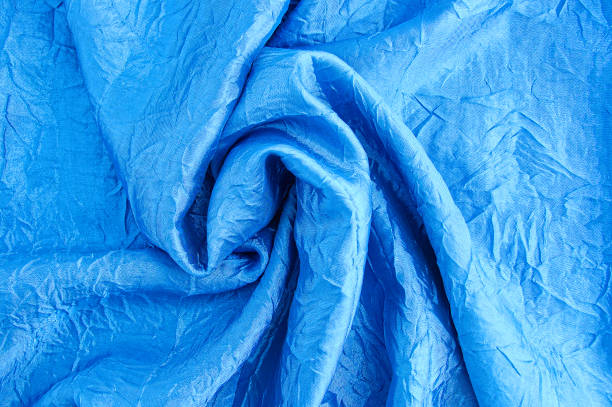 istock Close-up of blue satin fabric with a crinkled texture. 1289776192