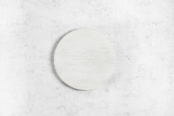 istock Wooden white cutting board over light stone background 1289776354