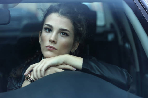istock Beautiful girl driving a car 1289777858