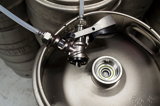 Top view of a beer keg with a detached coupler and pipes